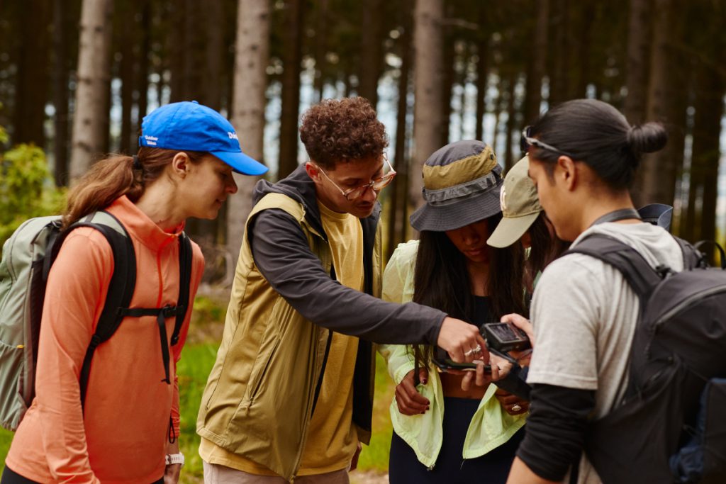 Groep wandelaars navigeren in het bos met behulp van de komoot-app.