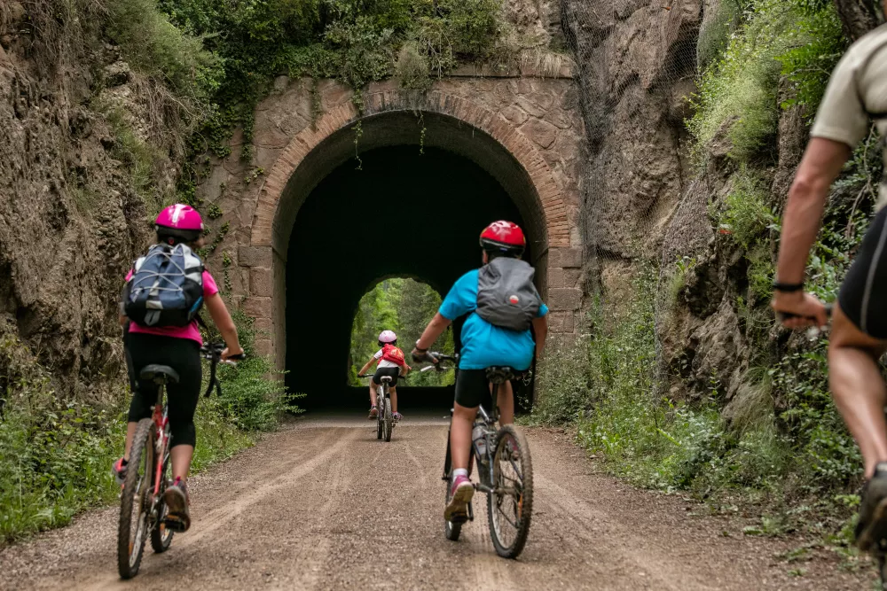 Fietsers passeren een oude treintunnel in Catalonië